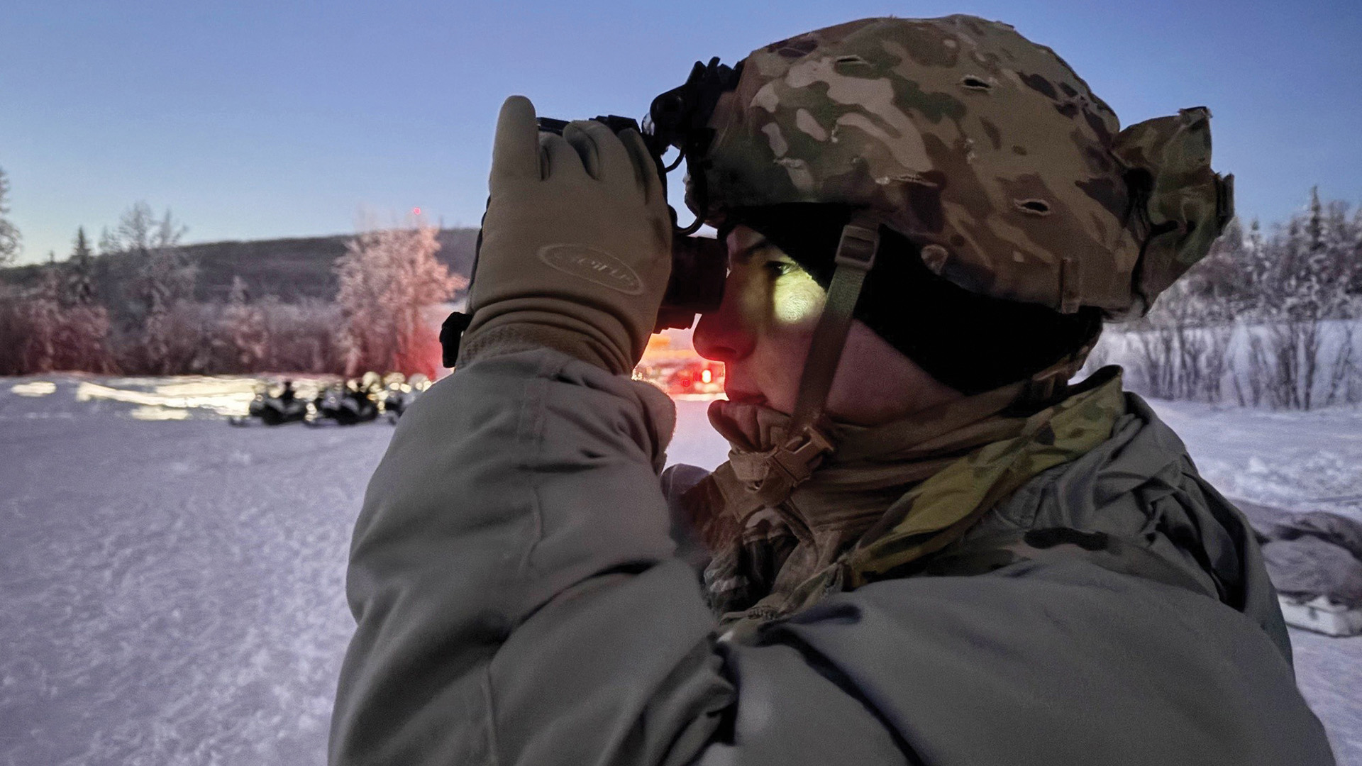 Picture of soldier testing and adjusting his night vision goggles.