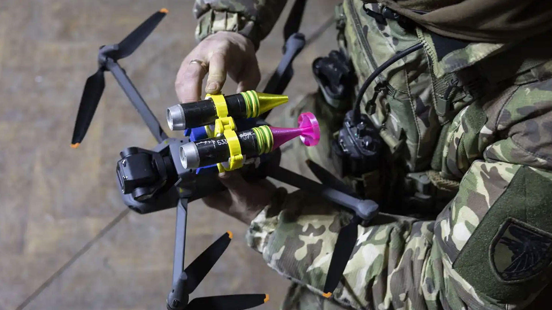 Ukrainian soldier arming a small drone with an explosive.