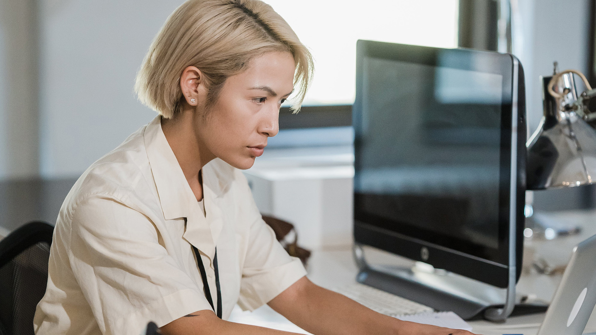 Woman focused on her laptop at an office desk