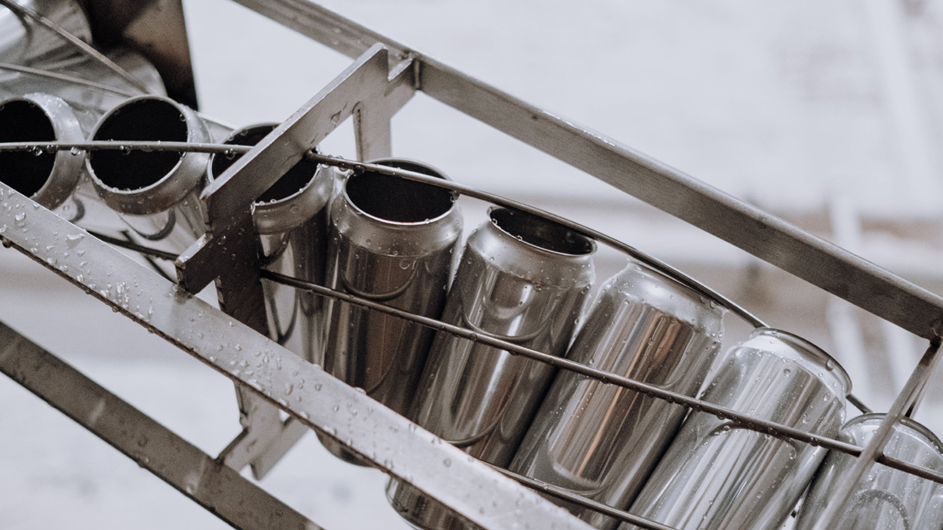 Stainless steel cans on an angled metal rack