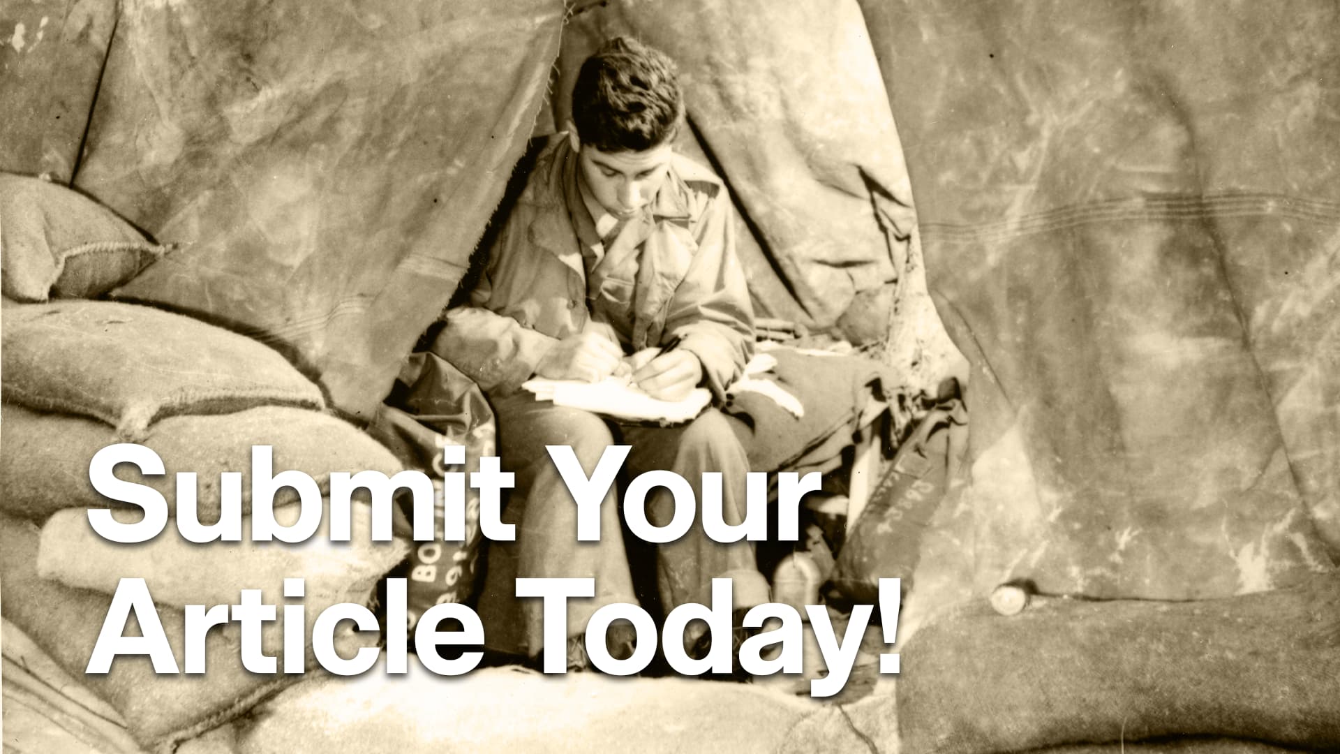 Soldier sitting on a cot inside of tent writes a letter.