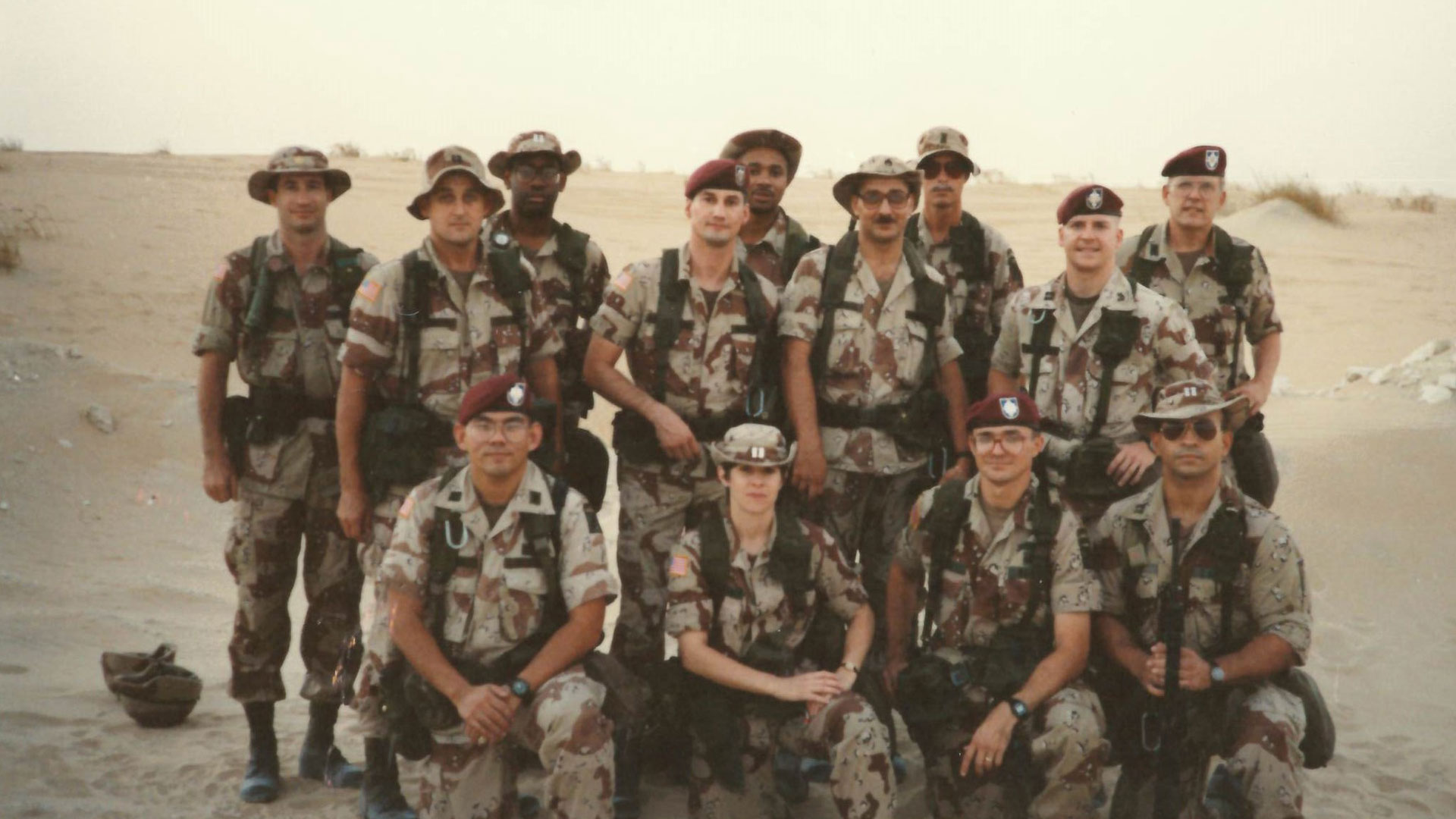 Group photo of U.S. Army soldiers in desert camouflage uniforms standing together in a desert setting.