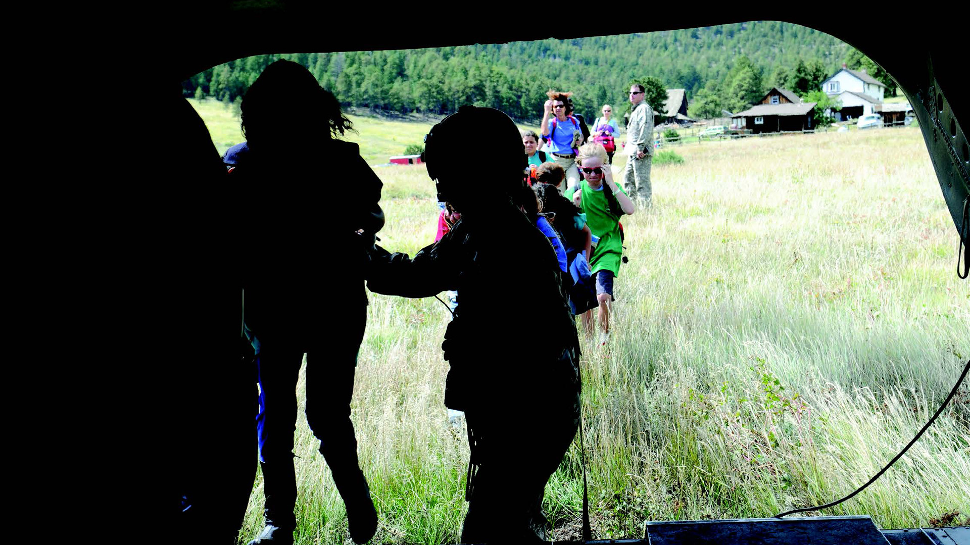 a picture of the 4th combat aviation brigade guiding elementary school students towards safety as they evacuate during extreme flooding
