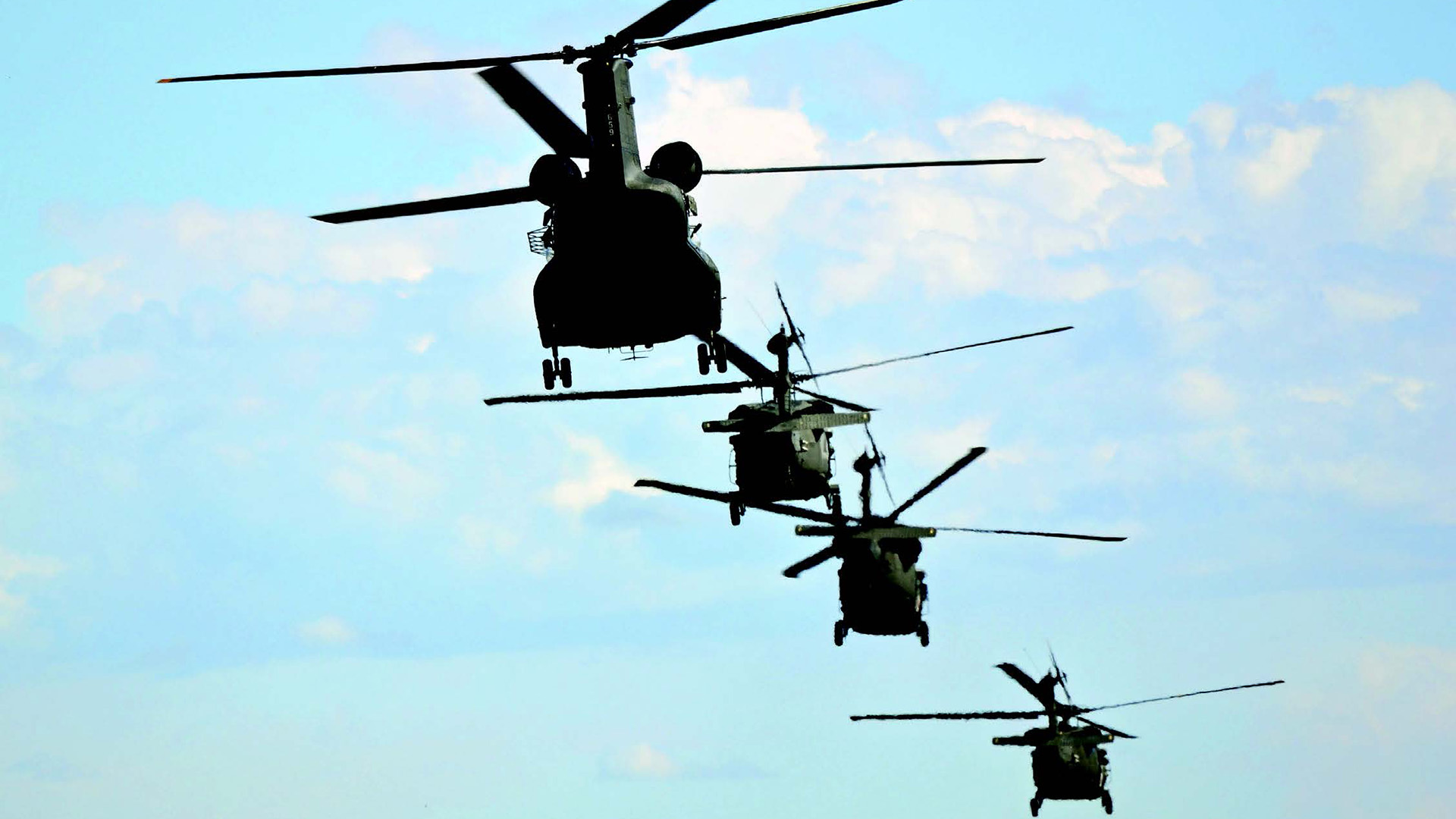 picture of 4 helicopters from the 4th combat aviation brigade, flying during rescue missions.
