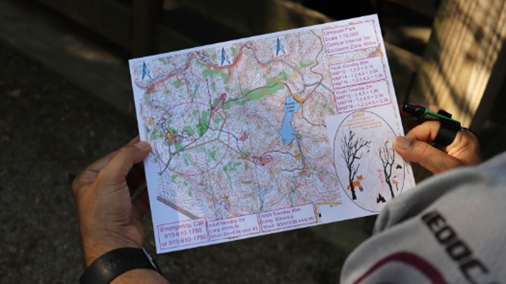 A participant in the amateur radio direction finding competition is attempting to study and orient himself with a map of the course. 