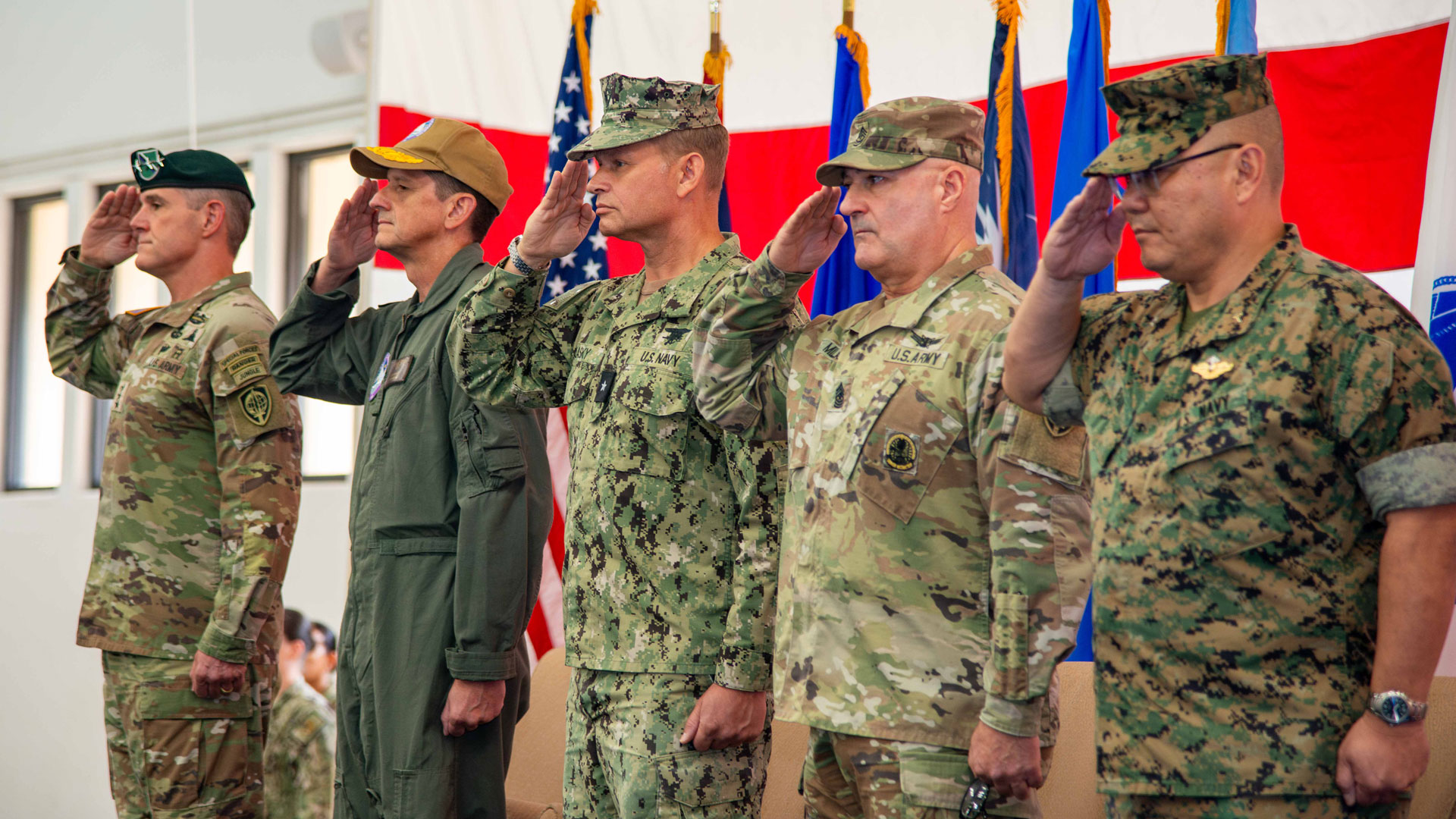 Senior leadership from the Army, Navy, and Air Force salute the colors as the national anthem plays during Joint Task Force ceremony.