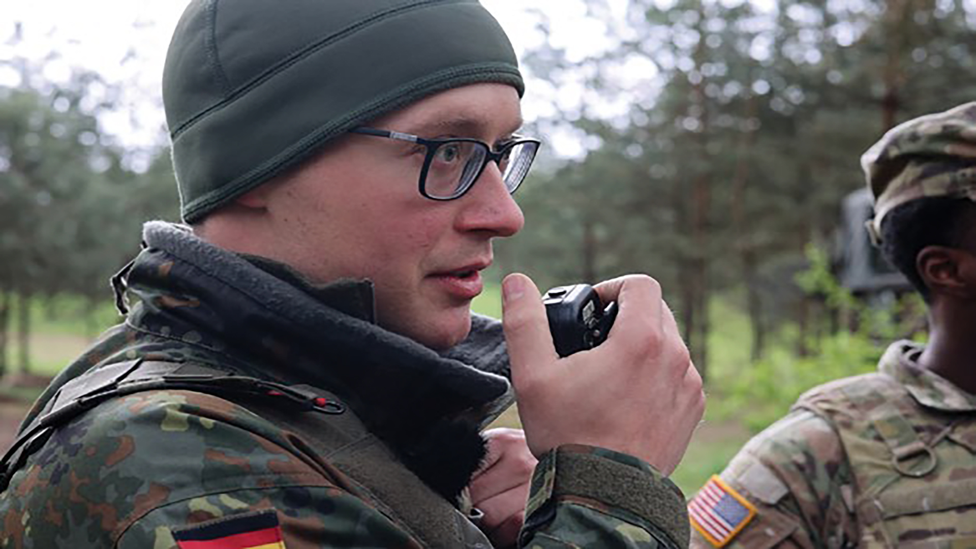 A photo of a German soldier speaks into a radio attached to a Radio Integration Communications Suite (RICS) during Saber Strike 24 on 18 April 2024. (Photo by SPC Andrew Clark)