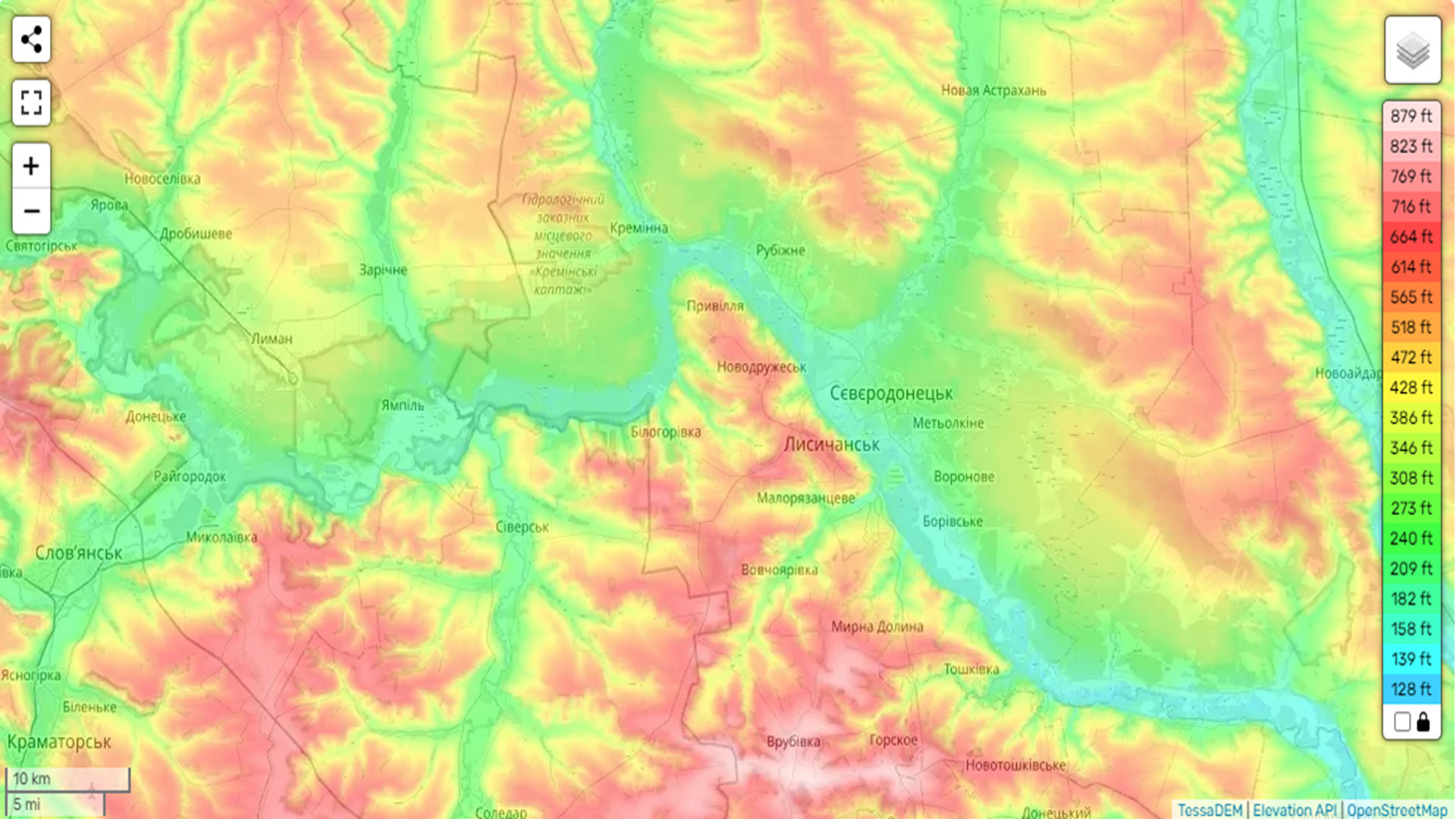 A color-coded elevation map of eastern Ukraine, focusing on the 
        Siverskyi Donets River region near cities such as Lysychansk, Severodonetsk, and Bilohorivka. 
        Elevation ranges from 128 ft (blue) to 879 ft (dark red), with green and yellow areas representing 
        lower elevations near the riverbanks. The map includes topographical gradients and labels for towns, 
        cities, and rivers relevant to the Battle of the Siverskyi Donets.